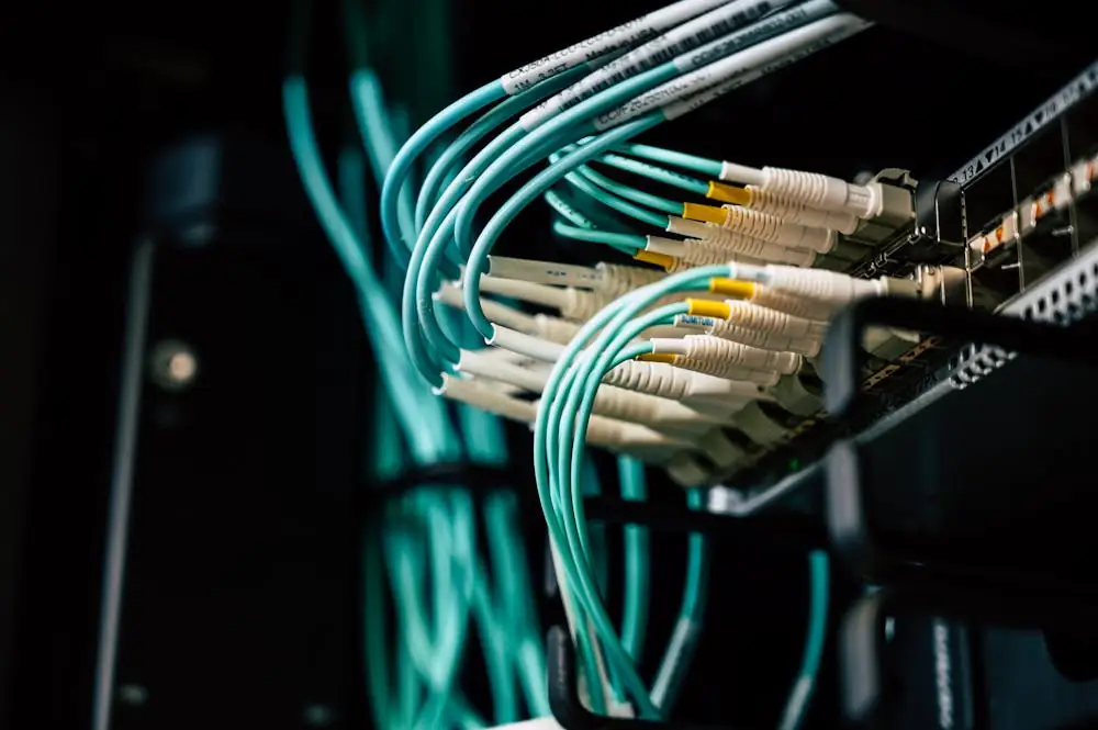 Fiber network cabling close-up with cyan indicator lighting